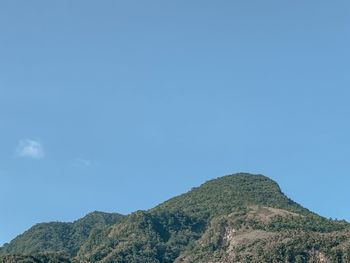 Low angle view of mountains against clear blue sky