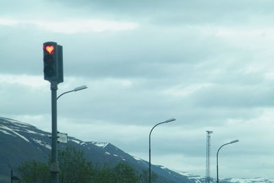 Road by mountains against sky