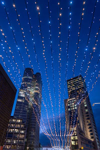 Low angle view of illuminated buildings against sky at night