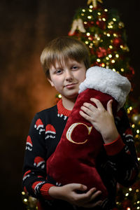 Portrait of cute boy holding christmas stocking 