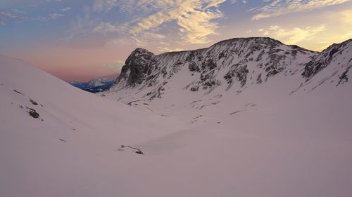 Scenic view of snowcapped mountain against cloudy sky