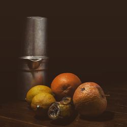Close-up of oranges on table against black background