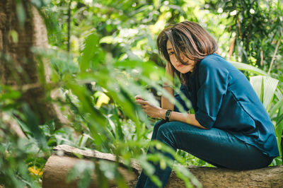 Portrait of woman sitting amidst plants