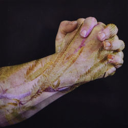 Close-up of human hand on table against black background
