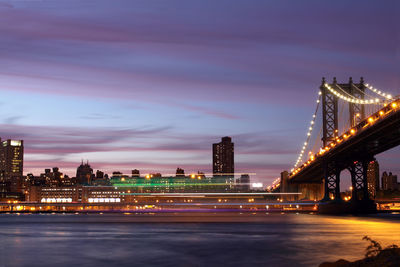 Long exposure of boat by manhattan bridge against sky at dusk