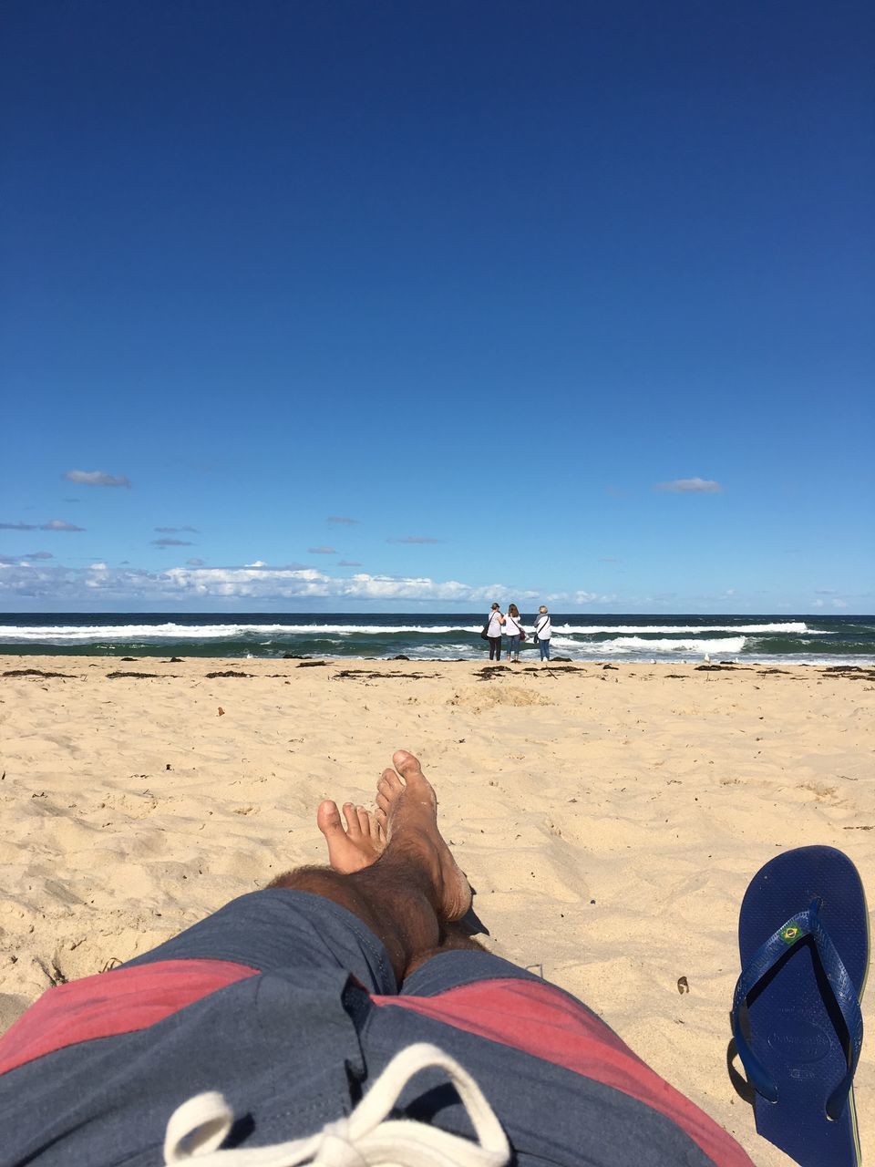 sea, horizon over water, beach, sand, low section, real people, human leg, blue, water, sky, leisure activity, personal perspective, sunlight, human body part, lifestyles, one person, scenics, nature, beauty in nature, men, day, outdoors, clear sky, vacations, close-up, people, adult, adults only, one man only