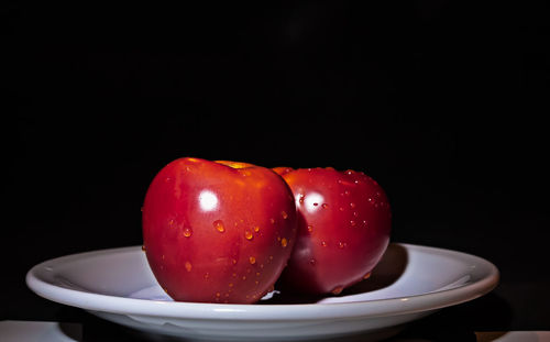 Close-up of strawberries in bowl against black background