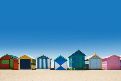 Beach huts against clear blue sky