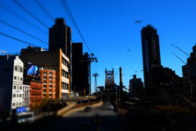 City street and buildings against clear blue sky