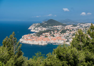 High angle view of townscape by sea against sky