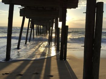 Pier on sea against sky during sunset