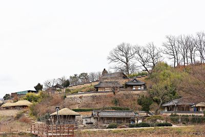 Houses and trees against sky