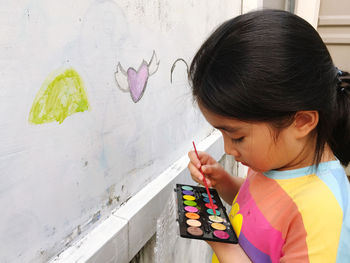 Side view of boy playing with abacus at home