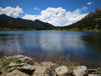 Scenic view of lake by mountains against sky