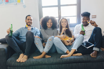 Portrait of happy friends sitting on the sofa