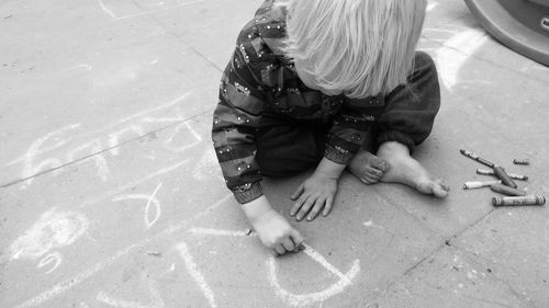 High angle view of boy writing text on street