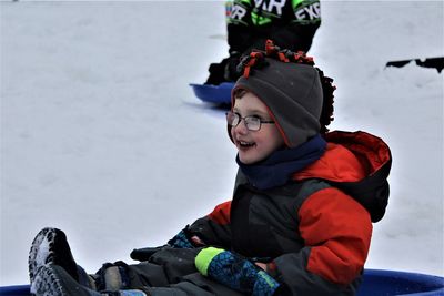 Smiling boy tobagging on snow