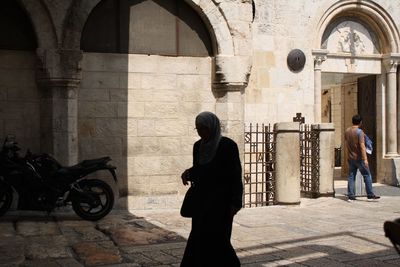 Woman wearing hijab walking on street