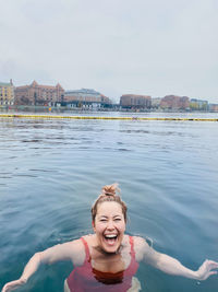 Smiling woman full of joy cold water swimming in denmark