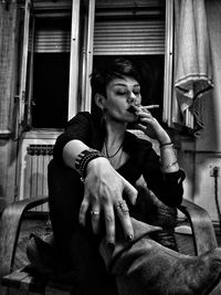 Mid adult woman holding cigarette at home