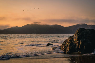 Scenic view of sea against sky at sunset