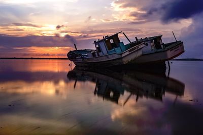 Boats in sea against cloudy sky