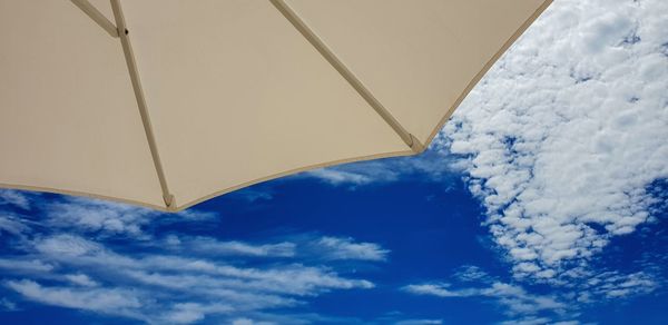 Low angle view of sunshade against sky