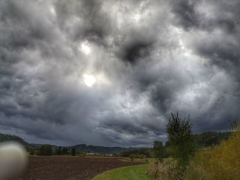 Scenic view of field against cloudy sky