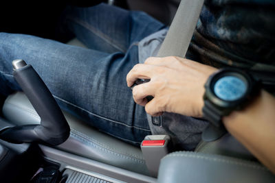 Midsection of man using mobile phone while sitting in bus