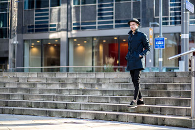 Portrait of man standing on steps in city