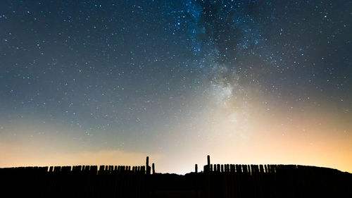 Low angle view of silhouette building against sky at night