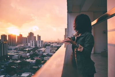 Man and cityscape against sky during sunset