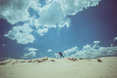Full length of man standing on beach against sky