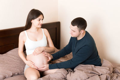 Young couple sitting on wall