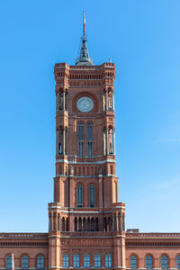 Low angle view of clock tower against blue sky