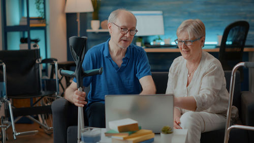 Senior couple using laptop at home