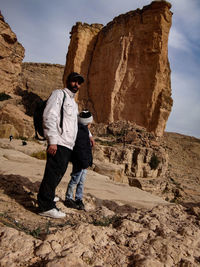 Full length of father and son standing on rock