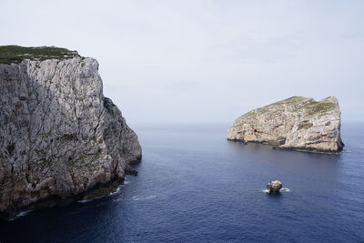 Rocks in sea against sky