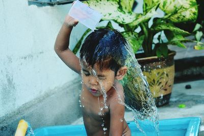 Cute boy bathing in back yard