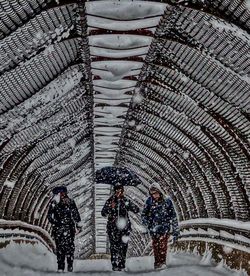 People walking on snow covered city