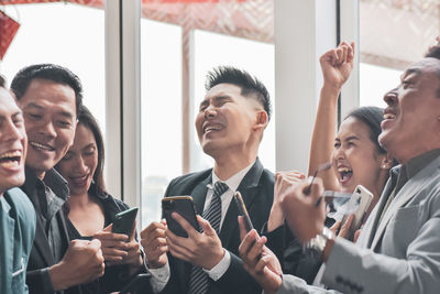 Colleagues using smart phone at restaurant