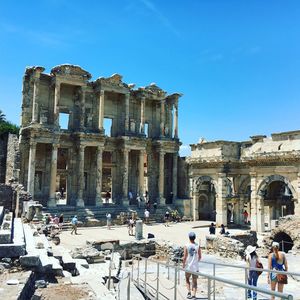 People at library celsus against blue sky