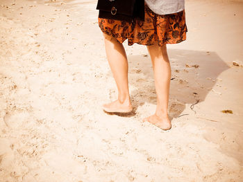 Low section of woman standing on beach