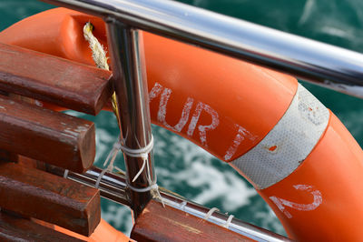 High angle view of life belt hanging on boat railing