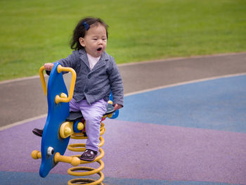 Young girl on playground equipment