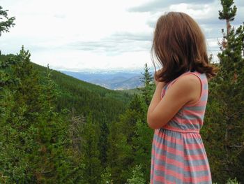 Rear view of woman looking at mountains against sky