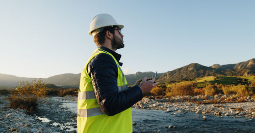 Engineer wearing hard hat standing on field