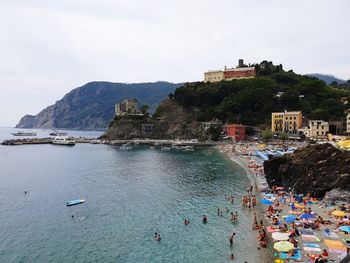 People on beach by mountain against sky