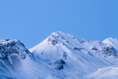 Scenic view of snowcapped mountains against clear blue sky