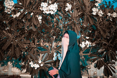 Low section of woman standing by plants